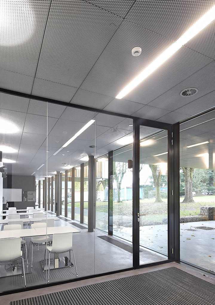Moderne look door combinatie van glazen systeemwand met metalen plafond